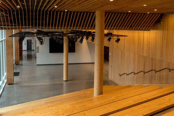 A room with tiered bench seating, support pillars and walls all made of wood.